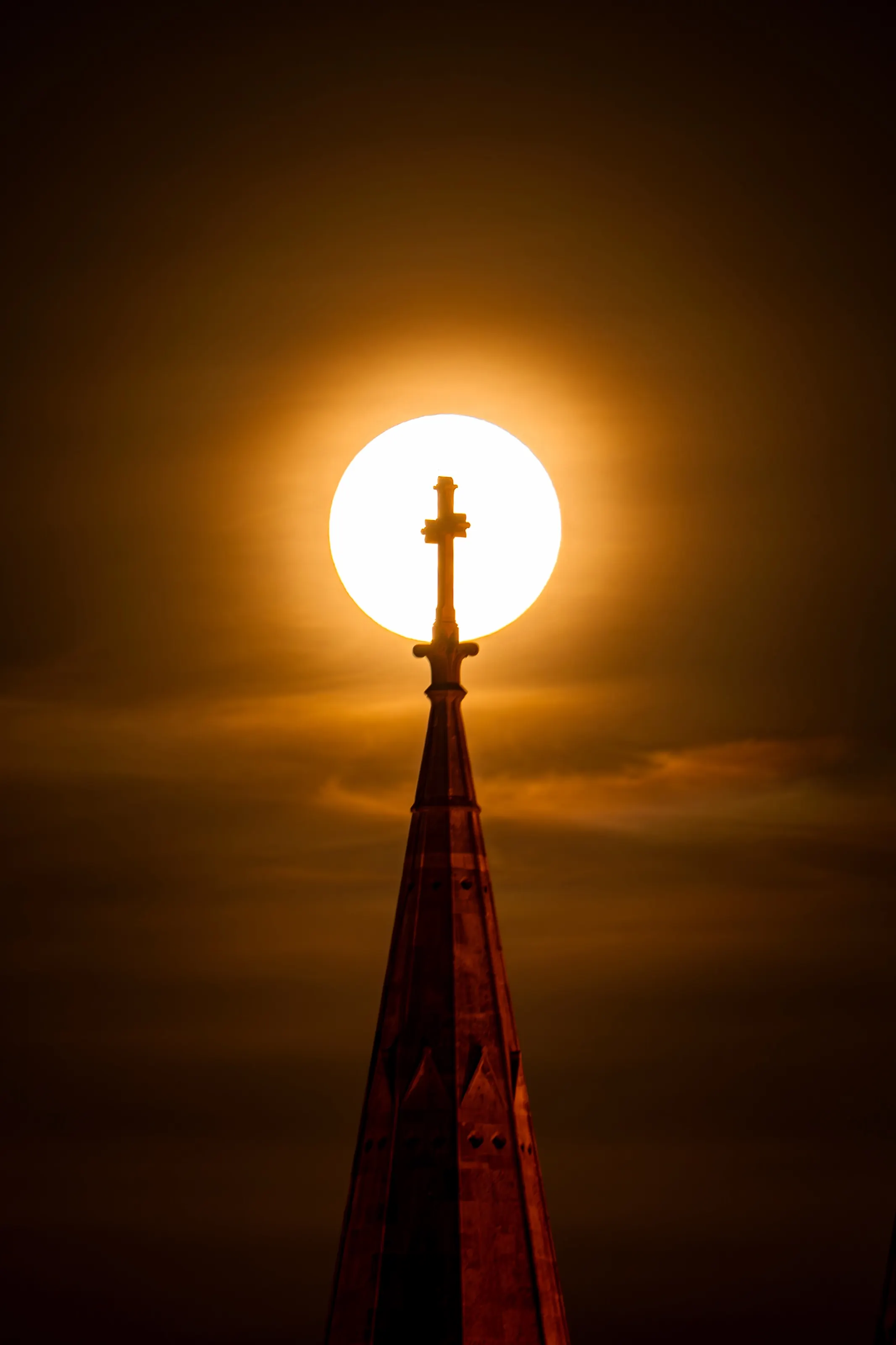 The sun aligned behind a cathedral cross