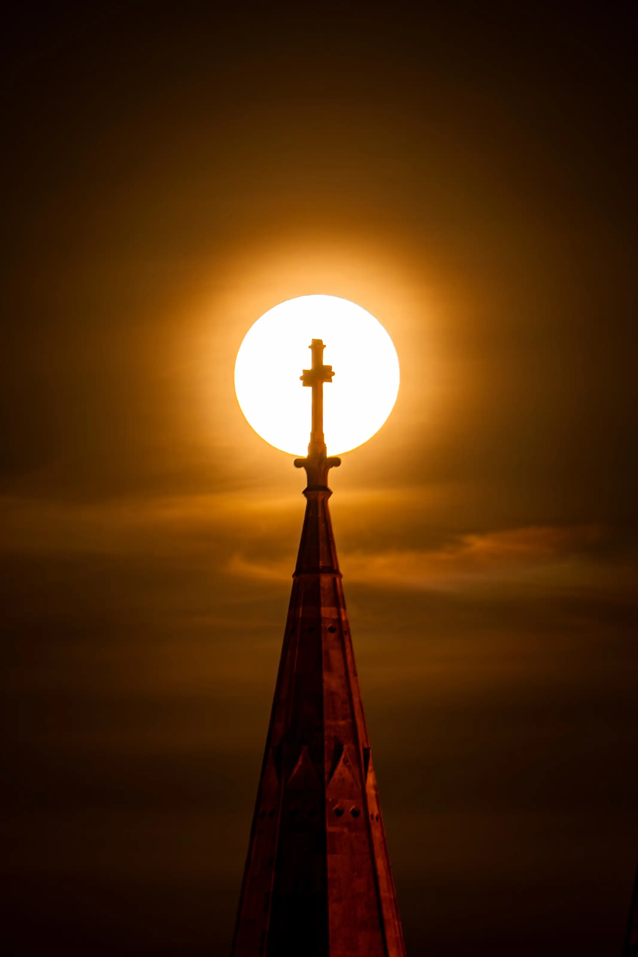 The sun aligned behind a cathedral cross
